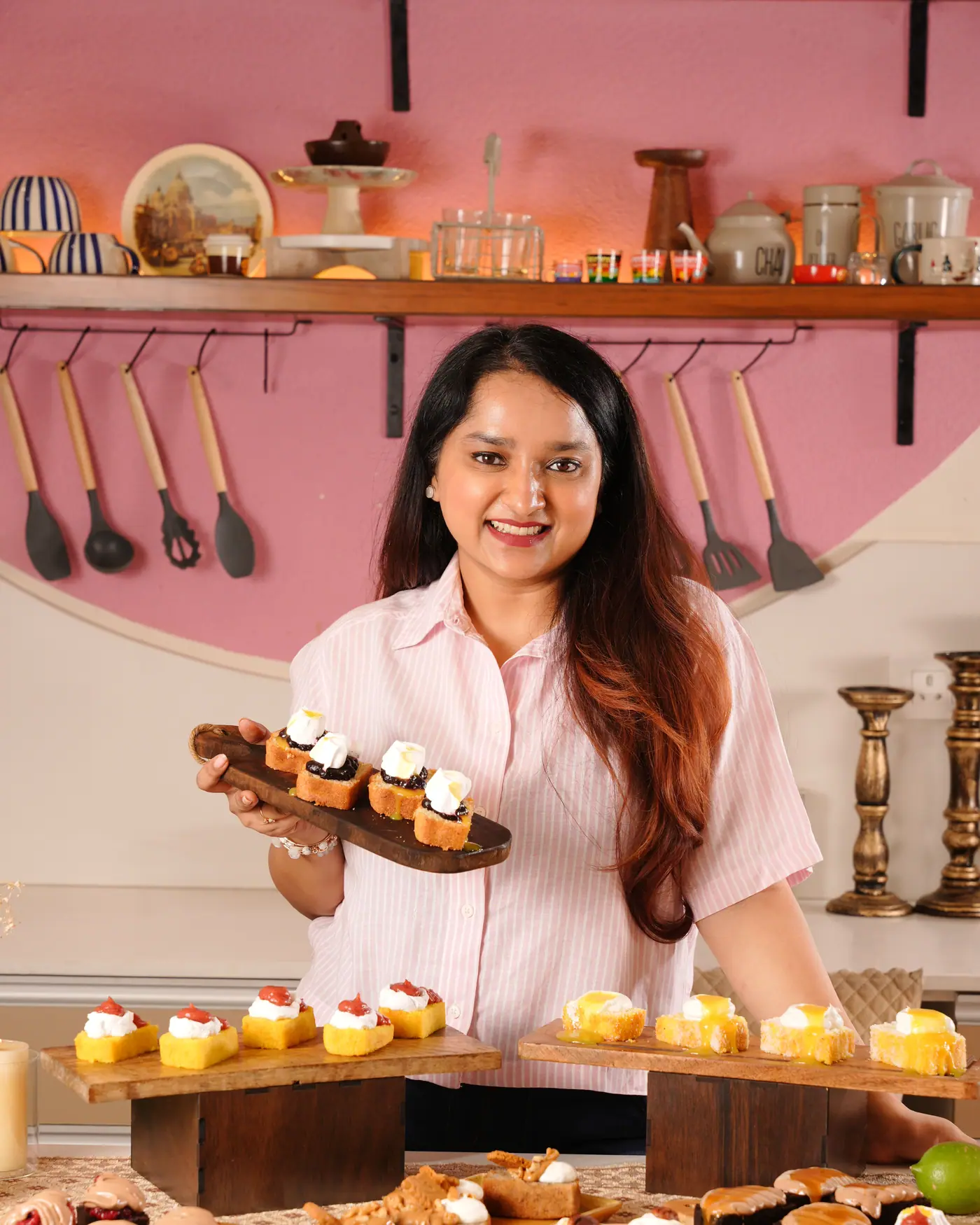 Anshita in her Panchkula studio, holding a board of cupcakes