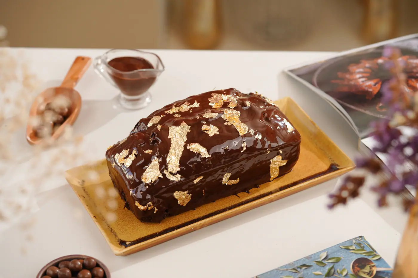 Chocolate tea cake with a glossy glaze and gold leaf